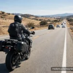 A rider in a helmet riding on a two-lane road with cars ahead