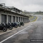 Track Days, Stunts & Racing: What's Excluded From Your Policy A closed racetrack pit lane with parked motorcycles and an empty track beyond, no racing in progress