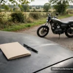 What Raises Your Motorcycle Insurance Rates: Tickets, Accidents, Claims A traffic citation booklet and pen on a car hood beside a parked motorcycle at a roadside stop